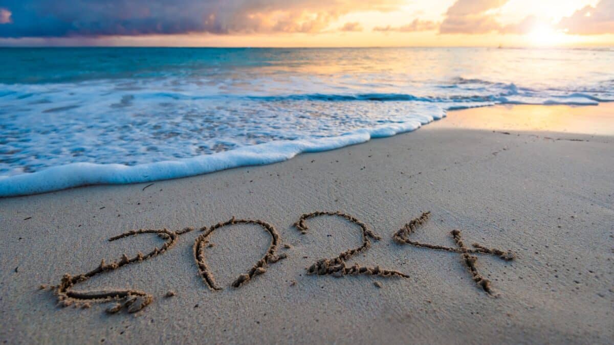 सूर्योदय के समय रेतीले समुद्र तट पर हस्तलिखित 2024 वर्ष संख्या